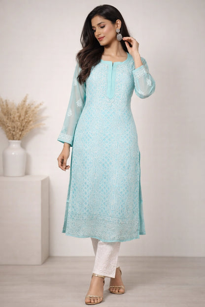 Woman wearing a lucknowi chikankari light blue kurta with white pants in a minimalistic setting.