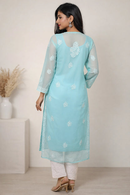 Woman wearing a light blue kurta with white floral embroidery against a neutral background