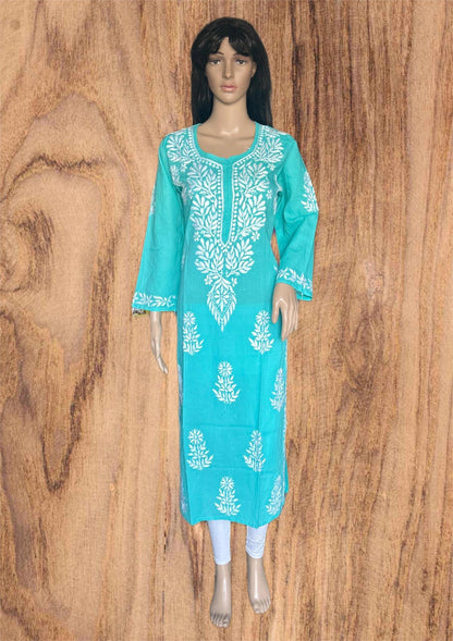 Green and white embroidered dress on a mannequin against a wooden background