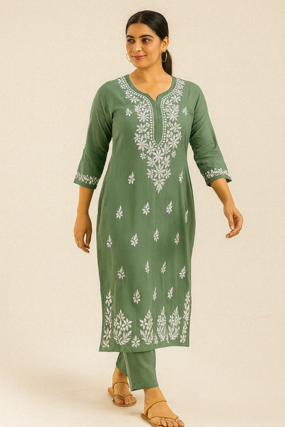 Woman wearing a green embroidered kurta with white patterns on a beige background