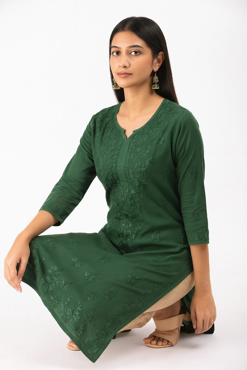 Woman wearing a lucknowi chikankari green dress with lace details on a white background