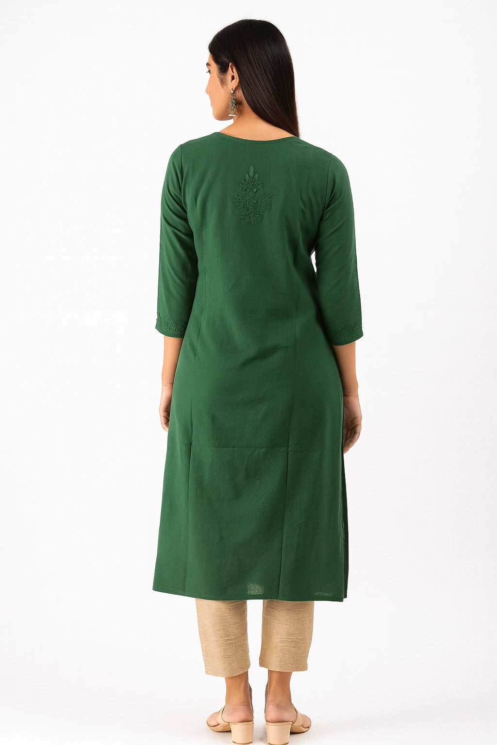 Woman wearing a lucknowi chikankari  green kurta with beige pants on a white background