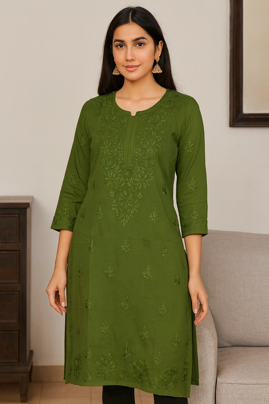 Woman wearing a green embroidered kurta in a room with a neutral background