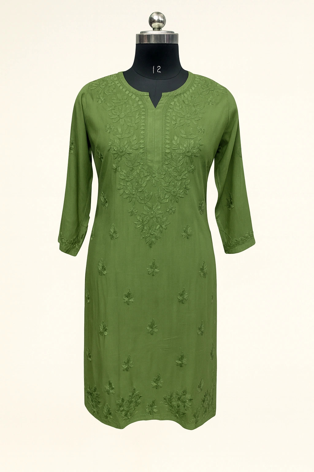 Green embroidered dress on a mannequin against a white background