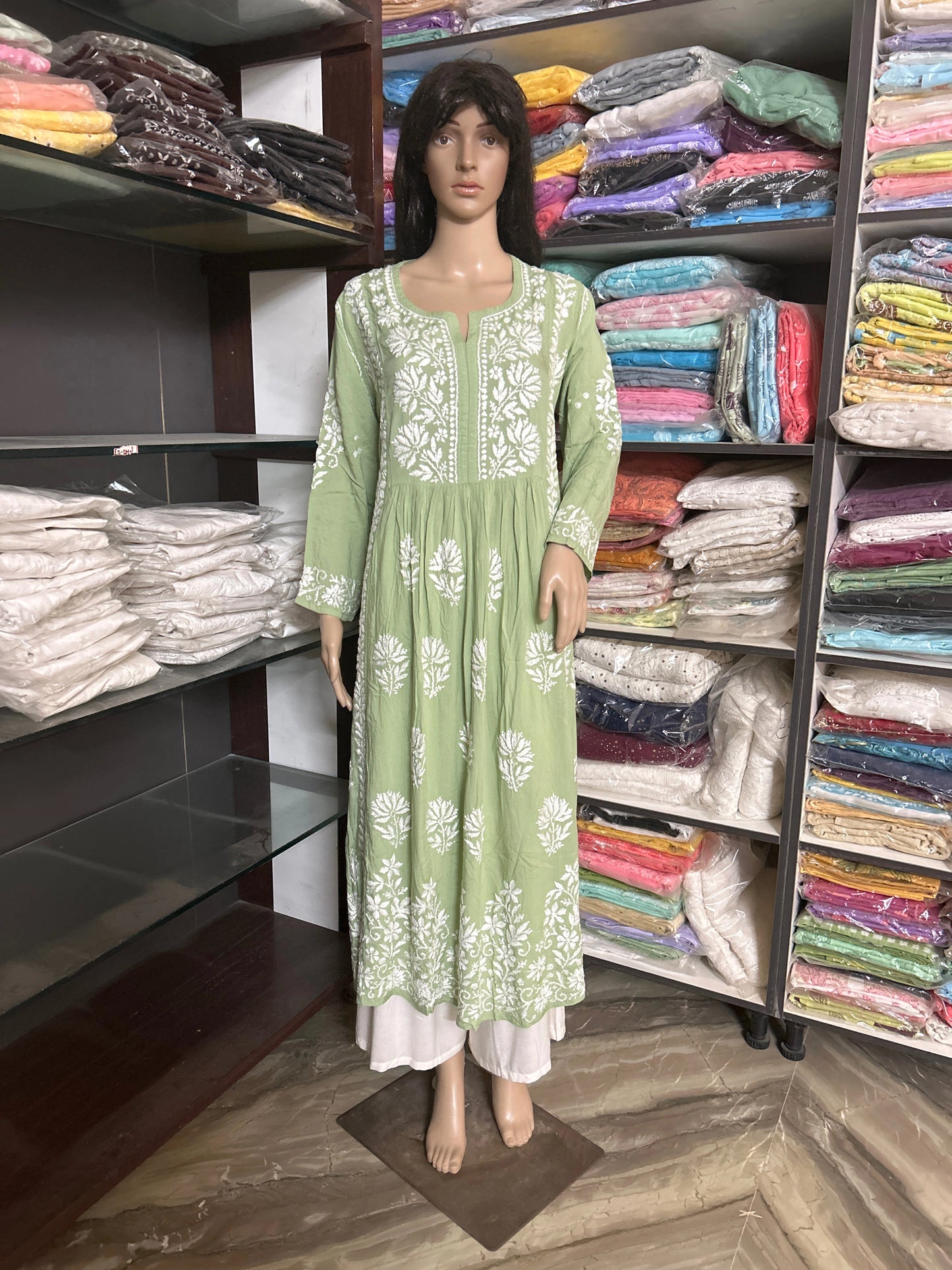 Green kurta with white floral embroidery on a beige background