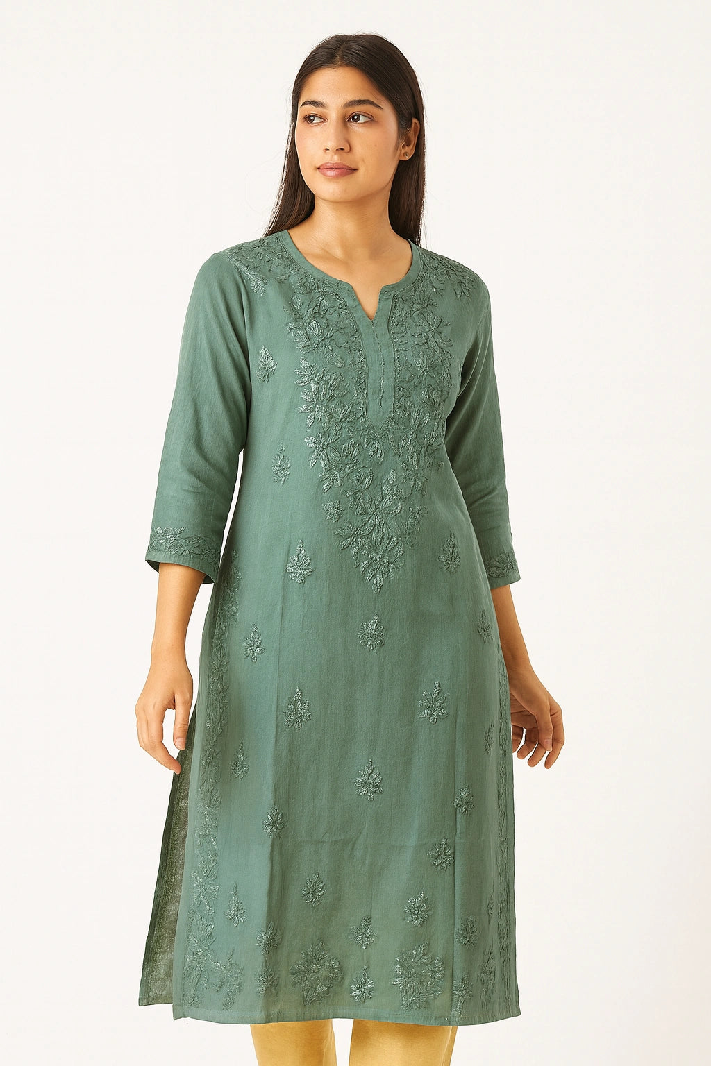 Woman wearing a green embroidered dress on a white background