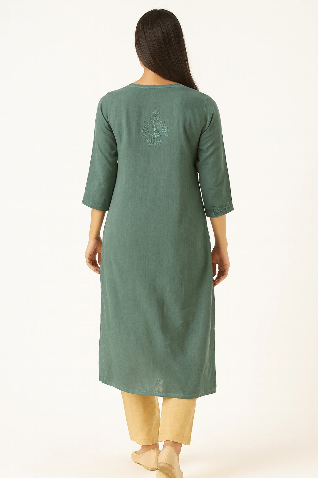 Woman wearing a lucknowi chikankari green kurta with a subtle design on a white background