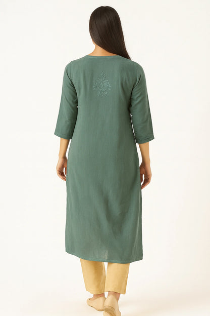 Woman wearing a lucknowi chikankari green kurta with a subtle design on a white background