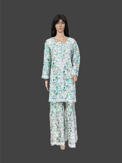 Lucknowi chikankari A mannequin wearing a long-sleeve kurta and matching wide-leg pants set with a white base and green floral pattern, shown against a dark gray background.