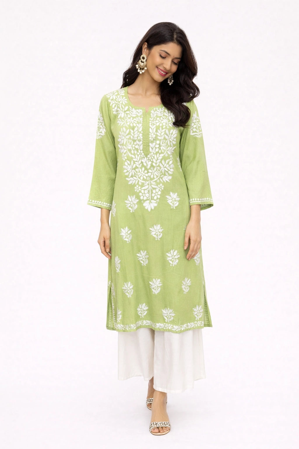Woman wearing a green kurta with white floral embroidery on a white background