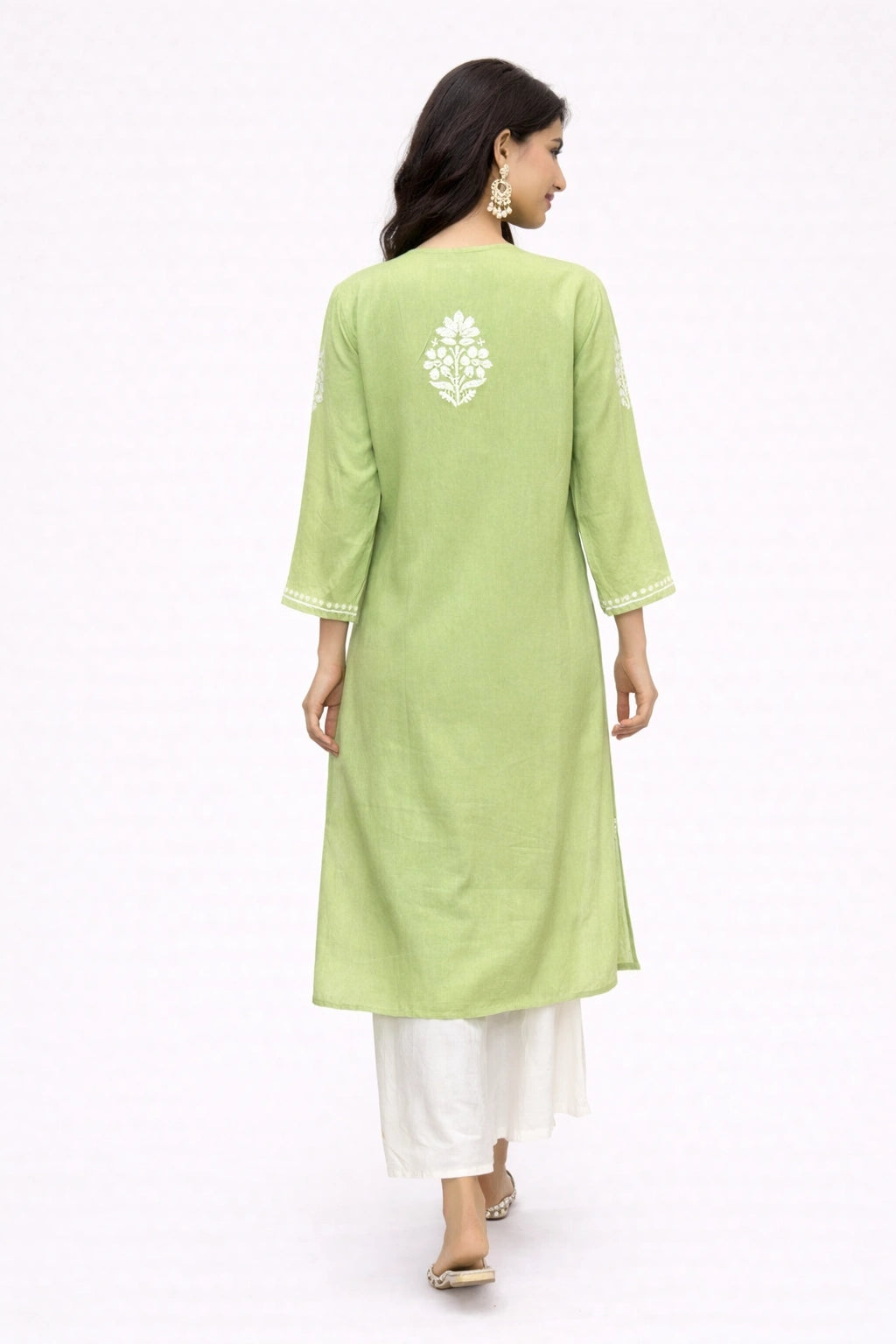 Woman wearing a light green kurta with white embroidery on a white background