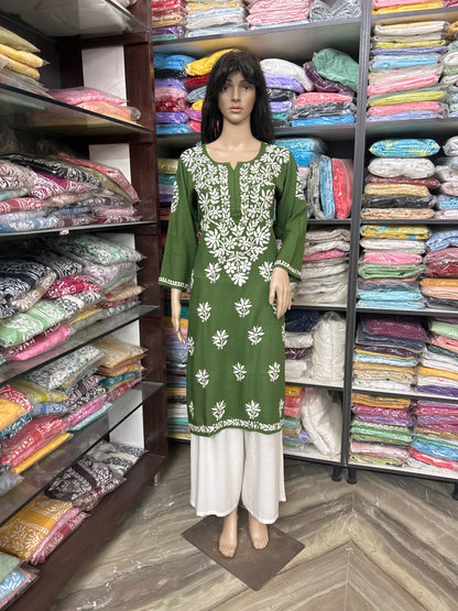 lucknowi chikankari Mannequin wearing a green and white dress in a fabric store.