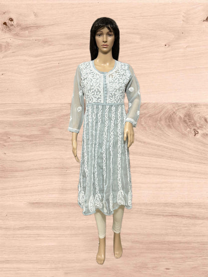 Light blue embroidered dress on a mannequin against a wooden background
