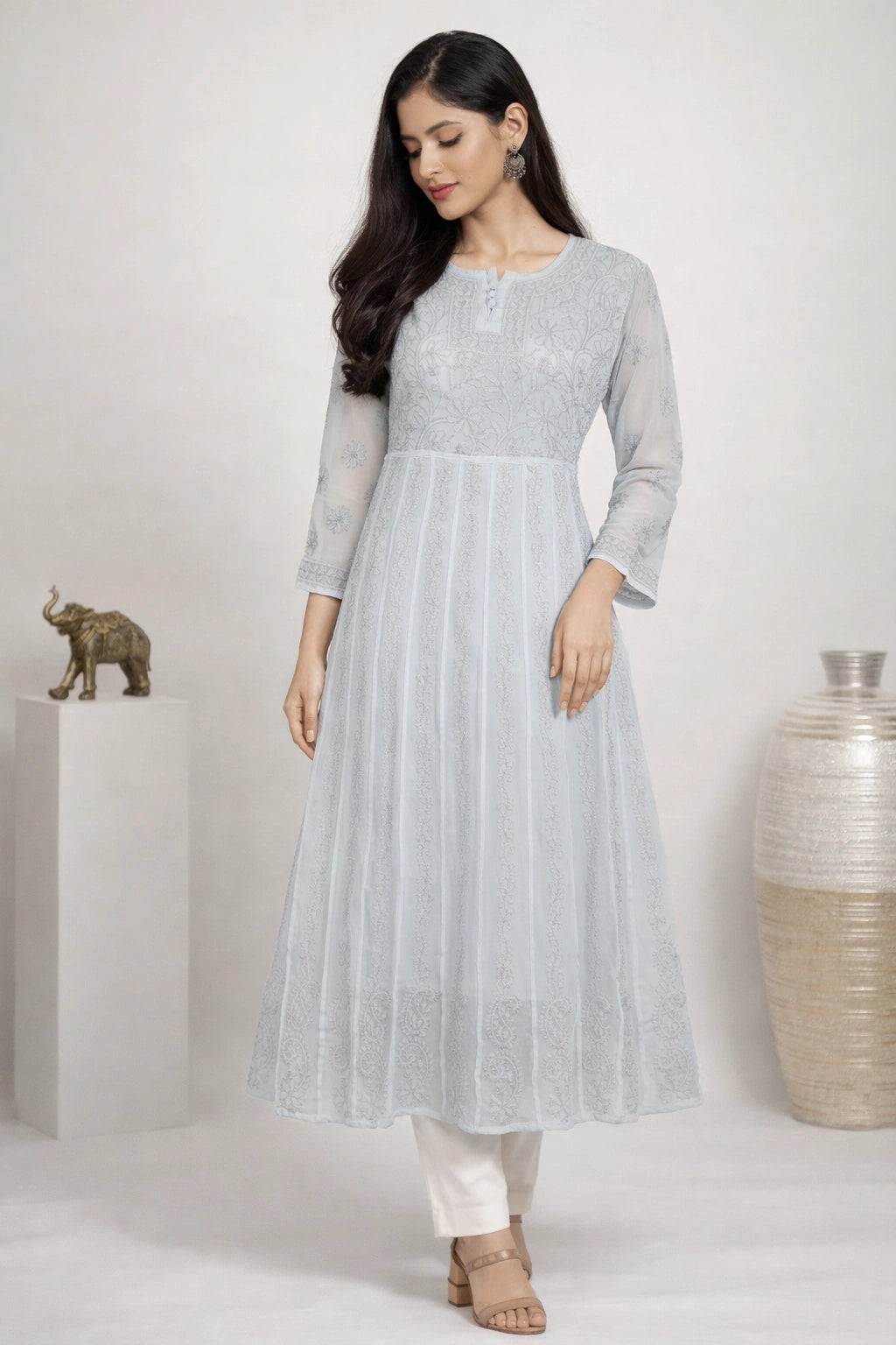 Woman wearing a chikan embroidery light gray dress with a white background
