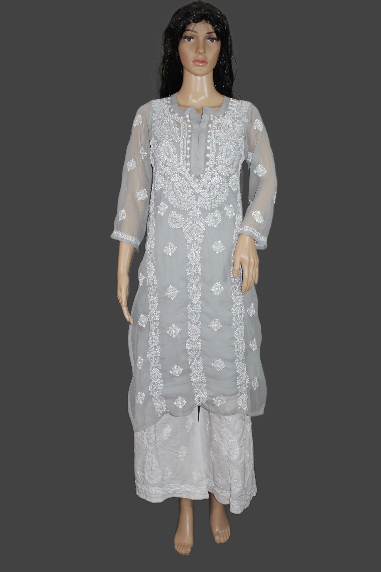 Gray embroidered traditional outfit on a mannequin against a gray background