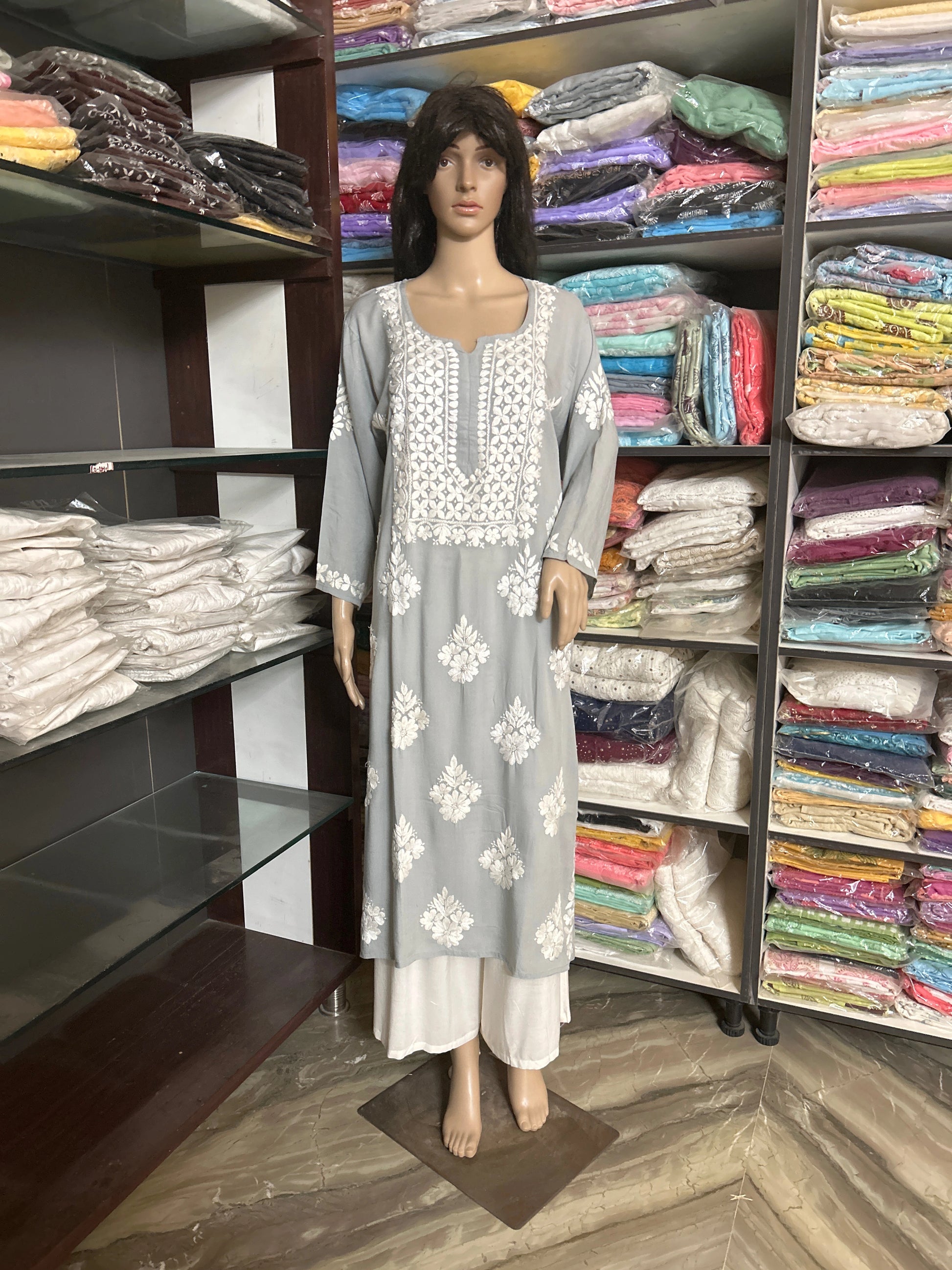 Grey kurta with white floral embroidery on a beige background