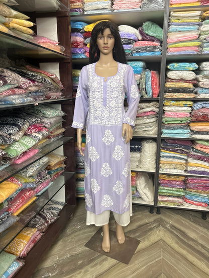Mannequin wearing a light purple dress with white floral patterns in a fabric store.