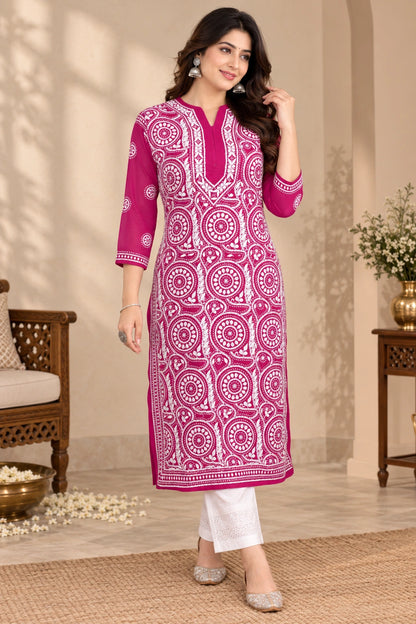lucknowi chikankari A woman modeling a bright magenta pink and white printed kurta with white pants in an indoor styled setting.