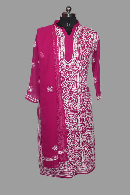 lucknowi chikankari A bright pink traditional tunic dress with white printed circular mandala patterns, displayed on a black mannequin against a solid gray background.