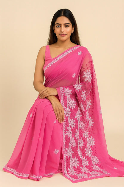 Woman wearing a pink saree with white floral embroidery on a beige background