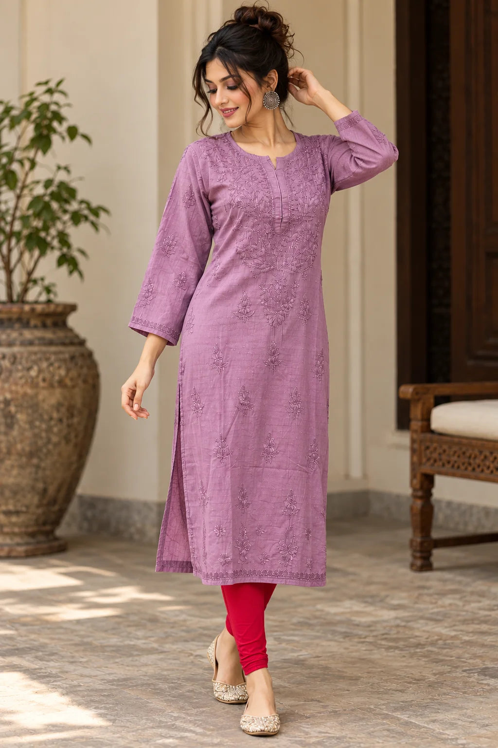 A woman models a lavender purple embroidered kurta with three-quarter sleeves, paired with bright red leggings and beige shoes, standing in an elegant indoor-outdoor corridor.