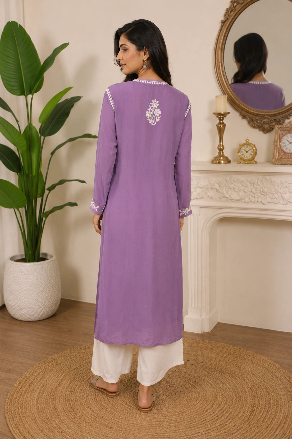 Woman wearing a mauve embroidered kurta with white pants in a minimalistic setting.