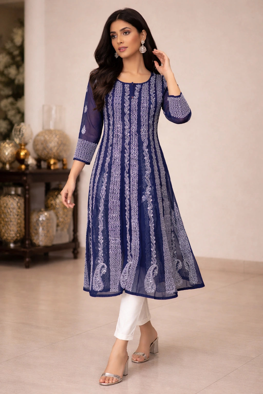 Woman wearing a blue lucknowi chikankari anarkali sitting on a chair.