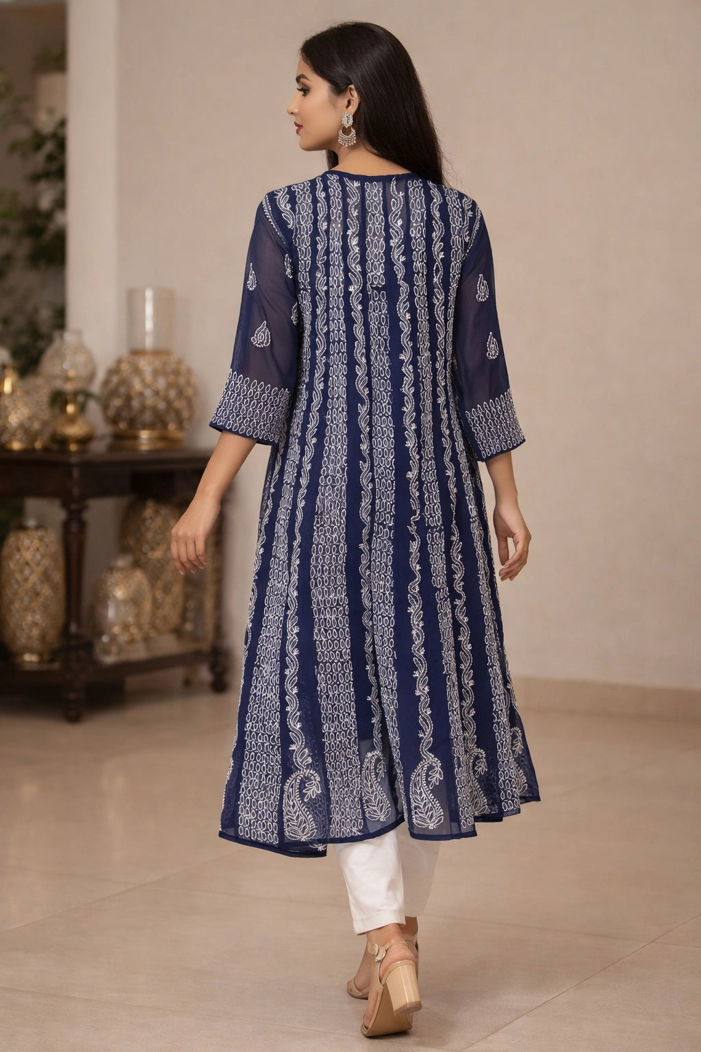 Woman wearing a blue lucknowi chikankari anarkali sitting on a chair.