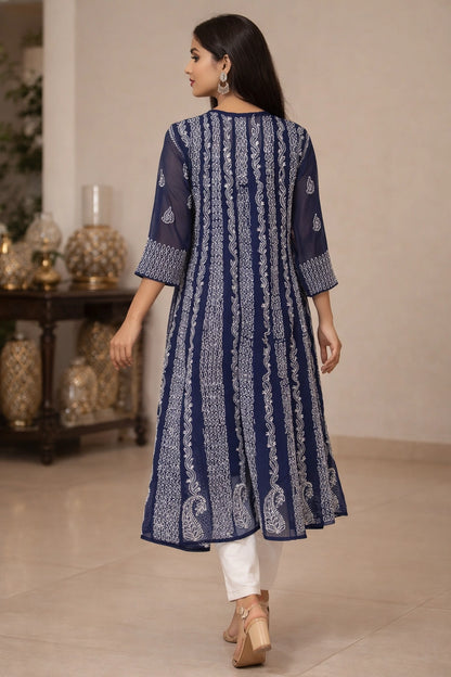 Woman wearing a blue lucknowi chikankari anarkali sitting on a chair.