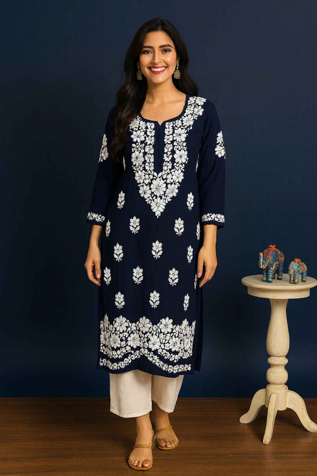 Woman wearing a navy blue kurta with white floral embroidery against a dark blue background.