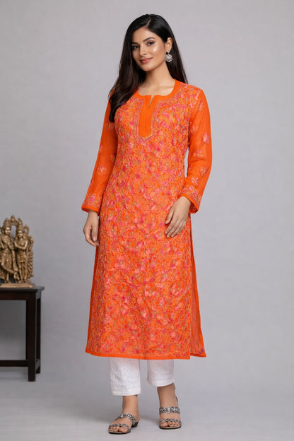 Woman wearing an orange and white floral kurta with white pants on a gray background