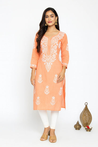Woman wearing a lucknowi chikankari peach kurta with a plain background