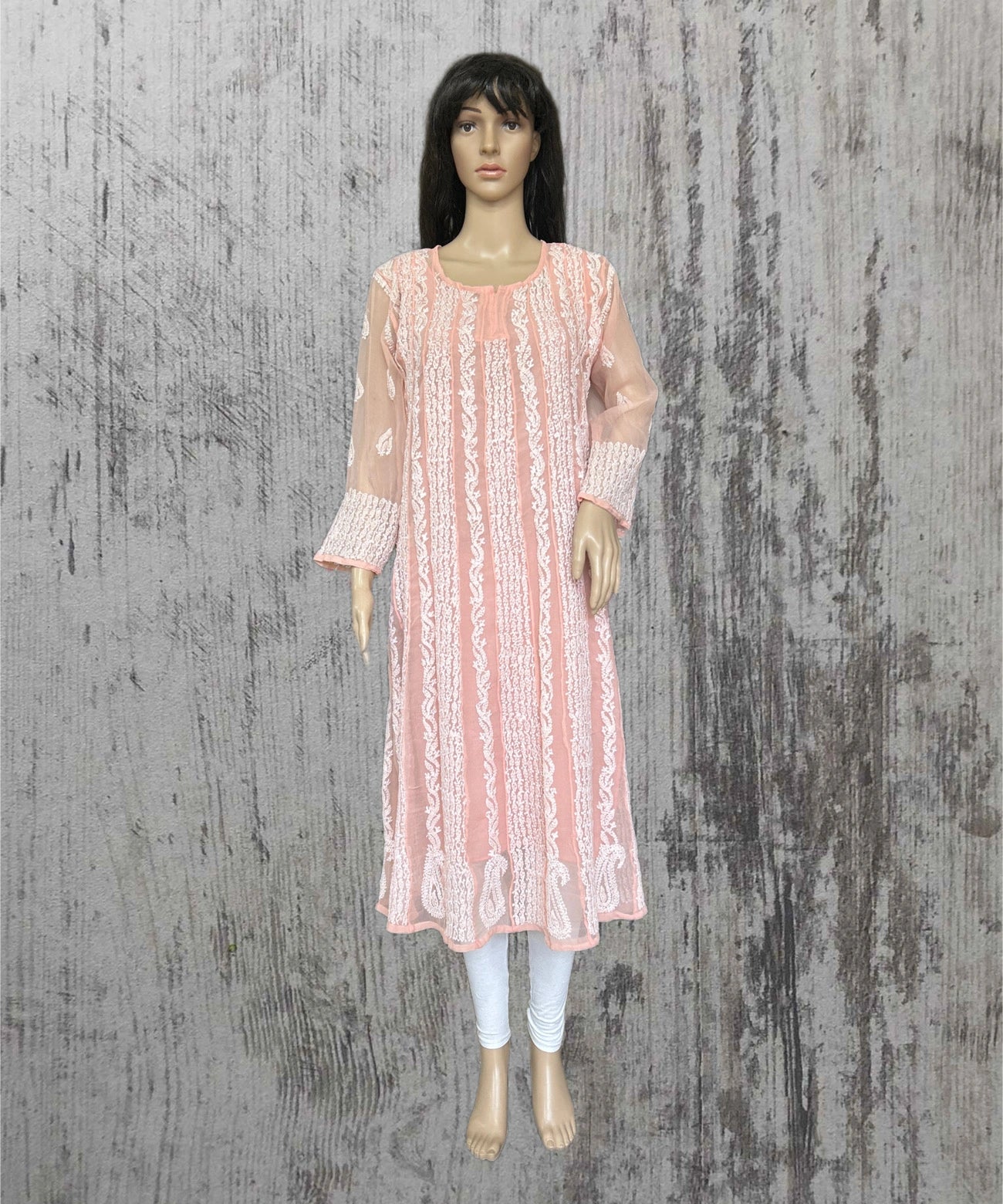 lucknowi chikankari Mannequin wearing a pink lace dress against a textured gray background