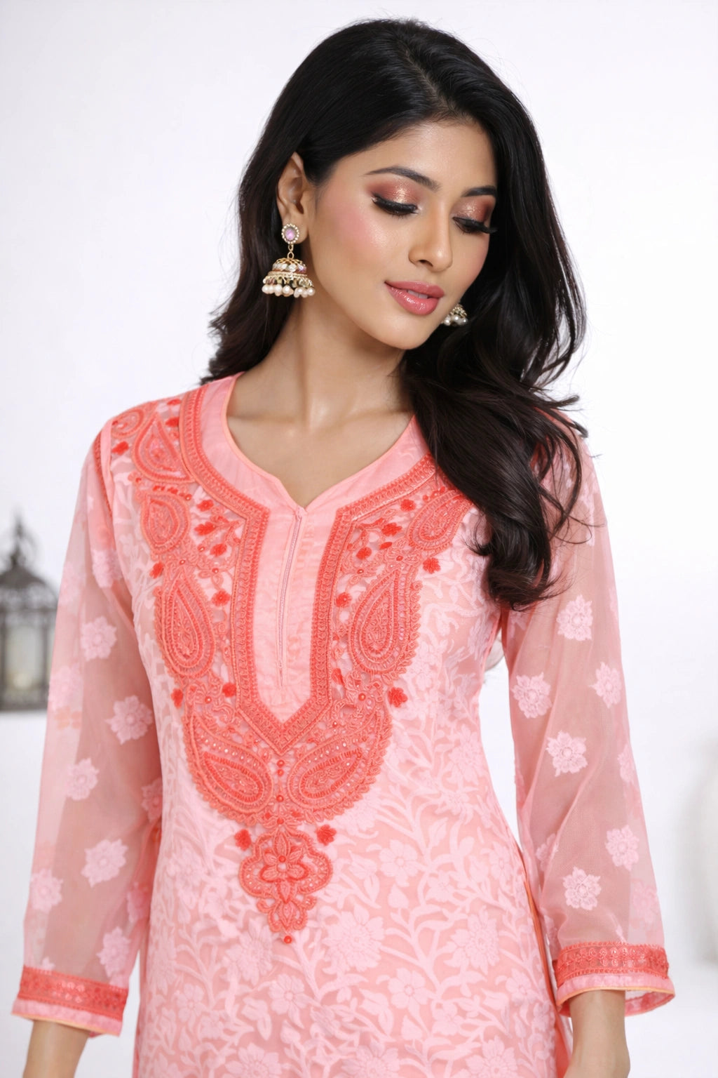 Woman wearing a pink kurta with white pants against a white background
