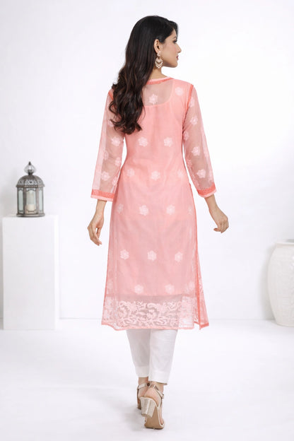 Woman wearing a pink kurta with white patterns on a white background