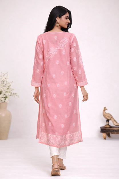 Woman wearing a pink kurta with white patterns on a white background