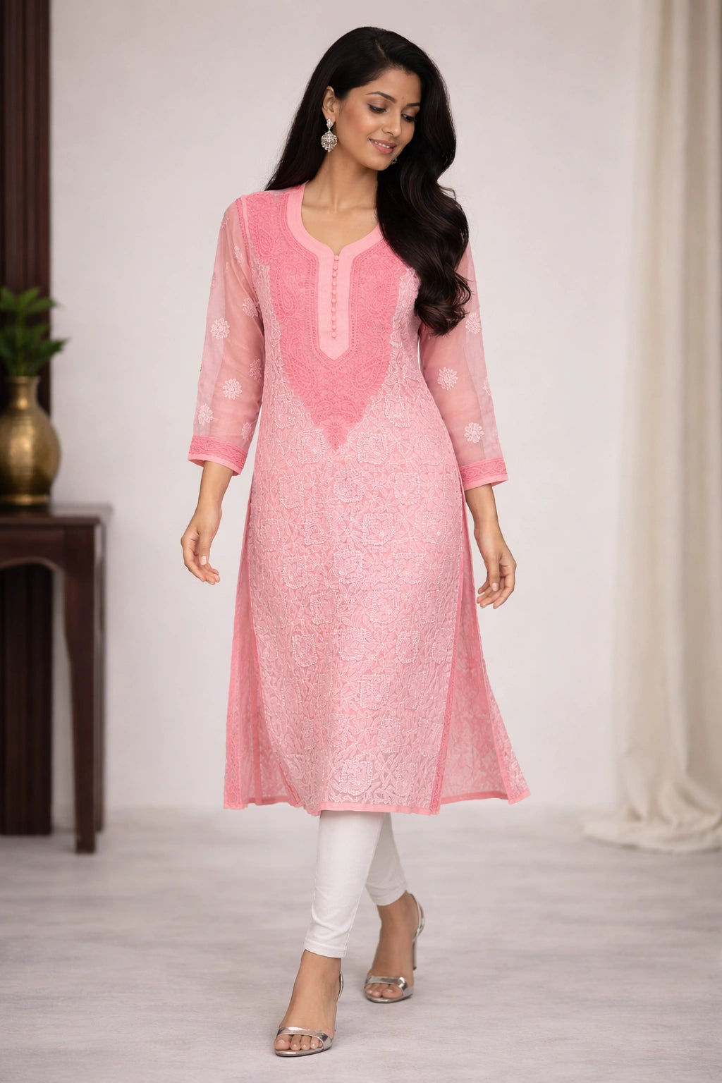 Woman wearing a pink kurta with white pants in a minimal indoor setting