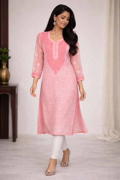 Woman wearing a pink kurta with white pants in a minimal indoor setting