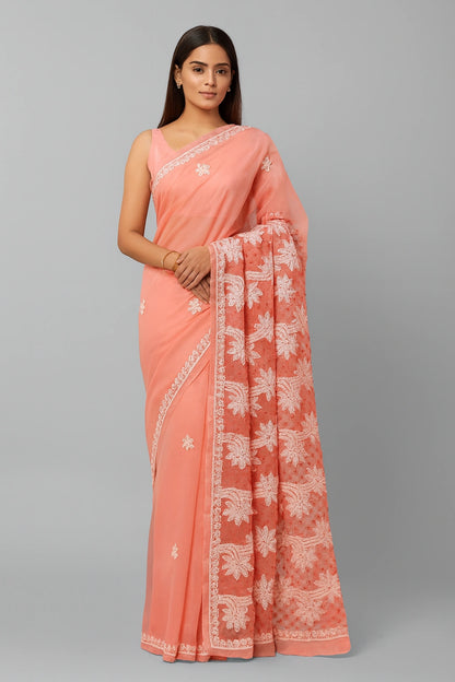 Woman wearing a lucknowi chikankari peach saree with white floral patterns on a gray background
