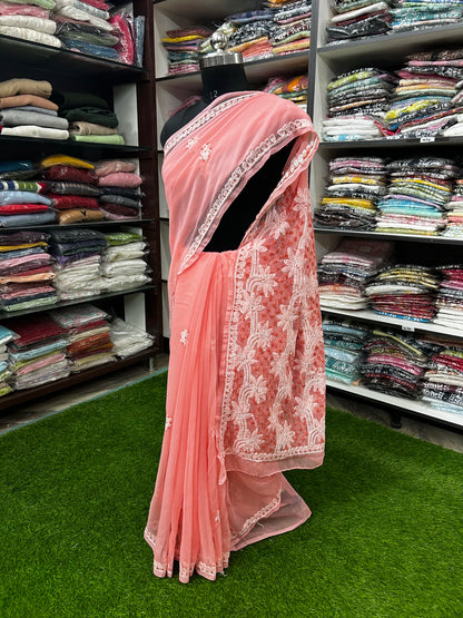 Pink saree with white embroidery on a mannequin in a fabric store.