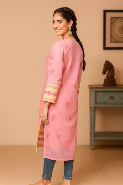 A woman viewed from behind wearing a pink long kurta with three-quarter sleeves and a subtle embroidered motif on the back, paired with denim and beige flat shoes in an indoor setting.