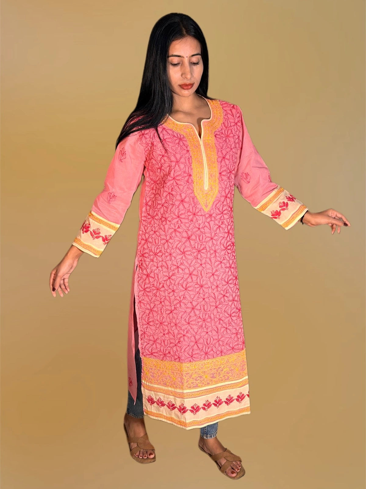 A pink embroidered kurta paired with denim.