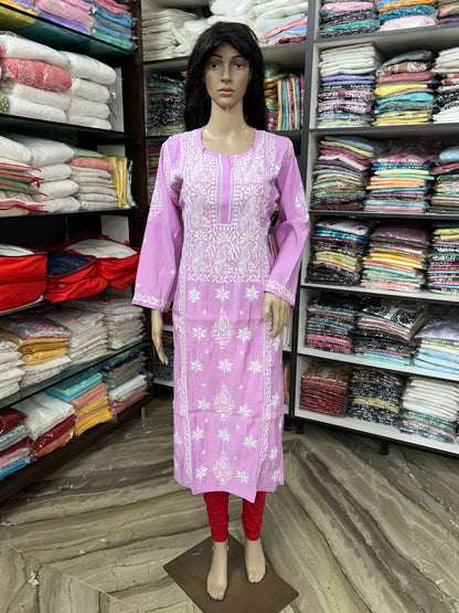 A white embroidered kurta with pink sleeves and red leggings displayed on a female mannequin in a clothing store.