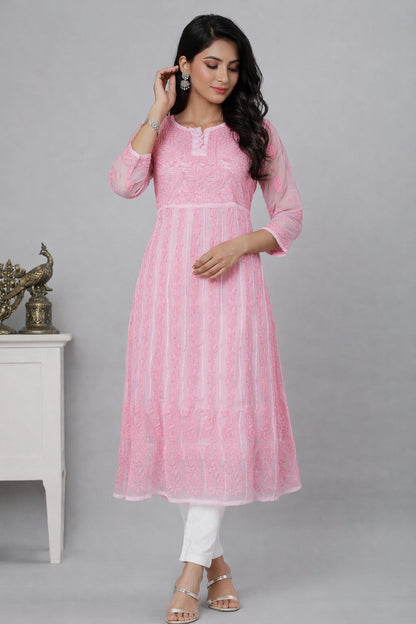 Woman wearing a chikan pink kurta with white pants against a gray background