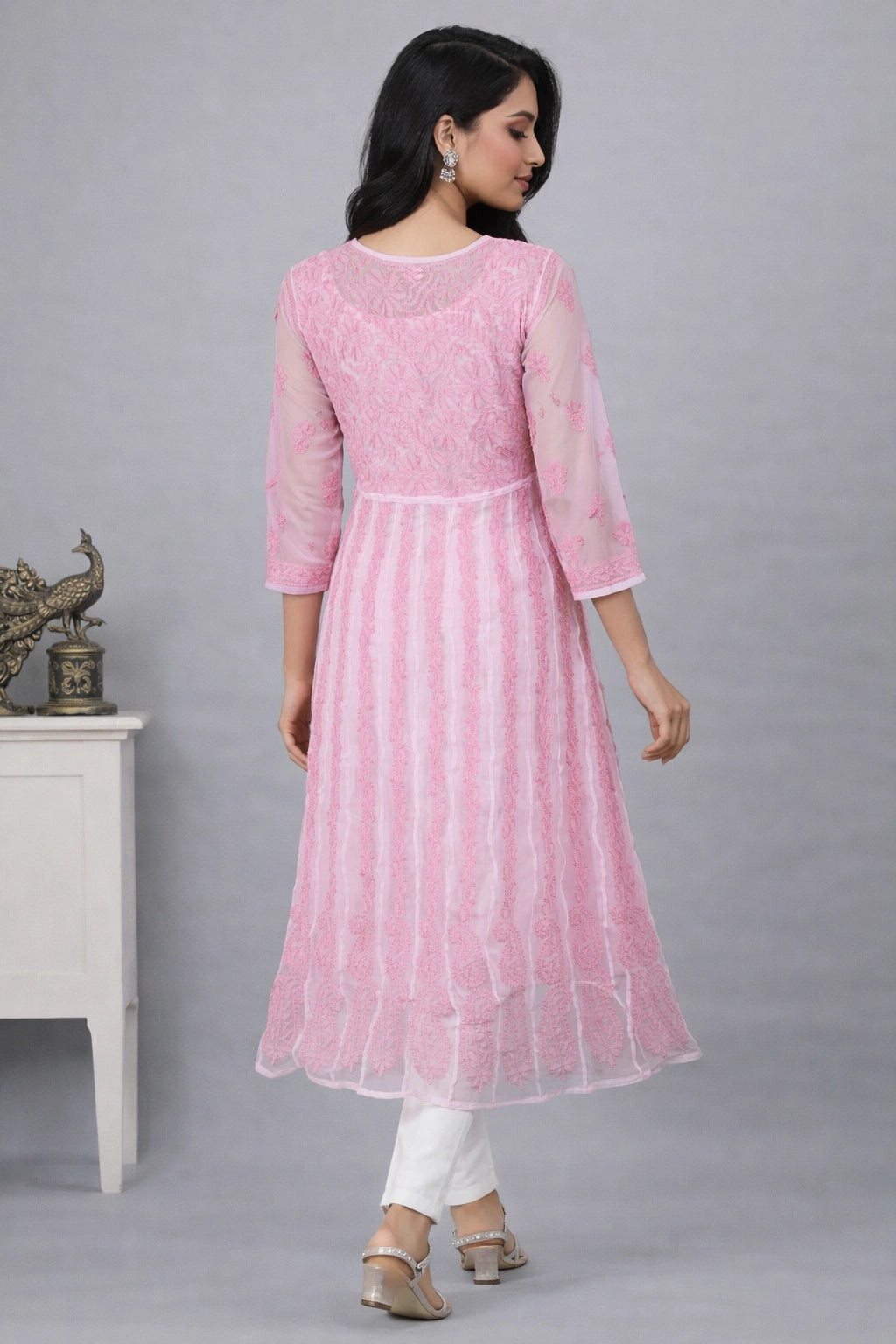 Woman wearing a lucknowi kadhai pink traditional outfit with white pants against a gray background