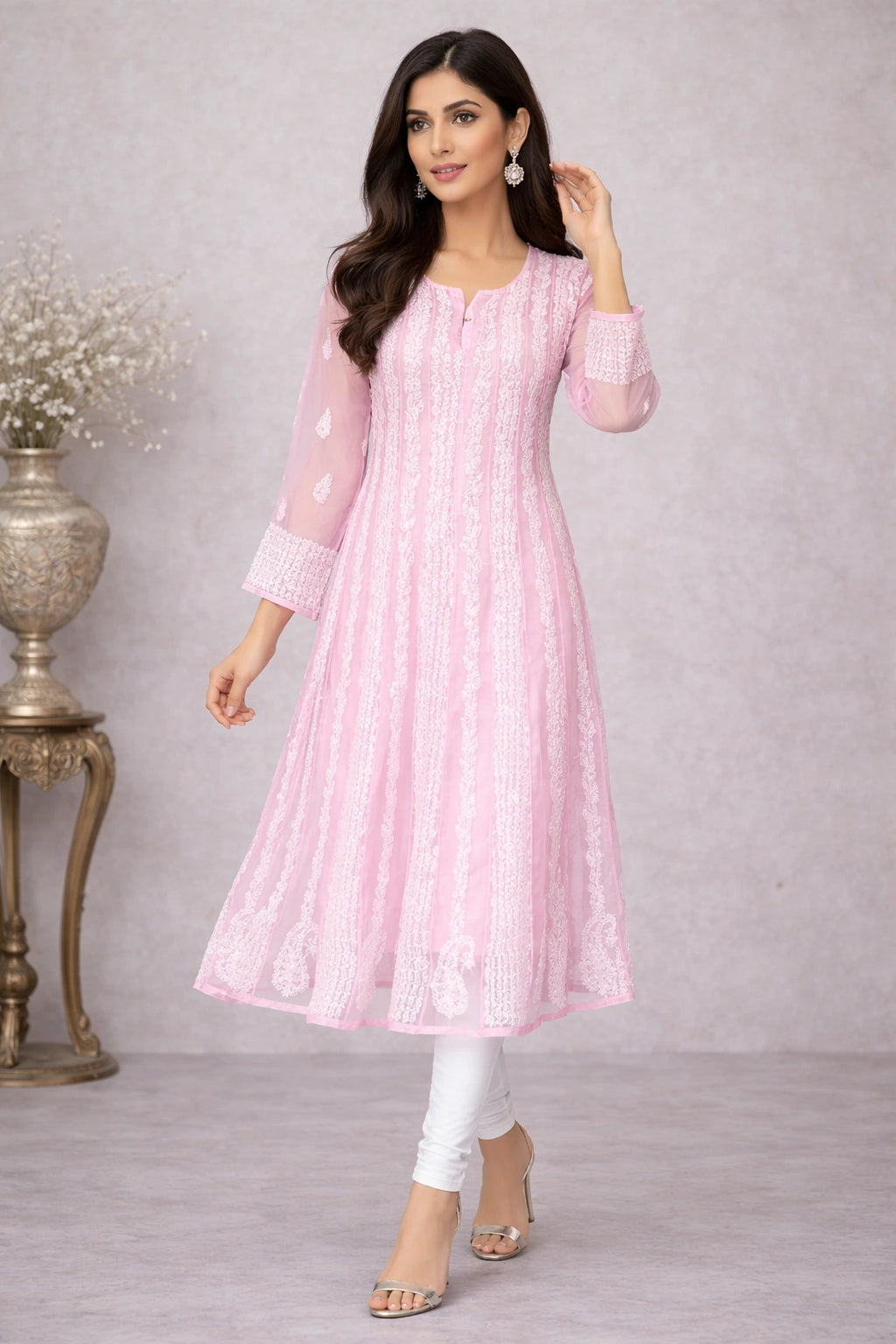 Woman wearing a  chikan kadhai pink traditional outfit with white pants against a gray background