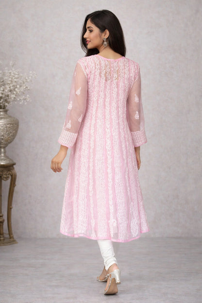 Woman wearing a chikankari pink traditional outfit with white patterns on a gray background