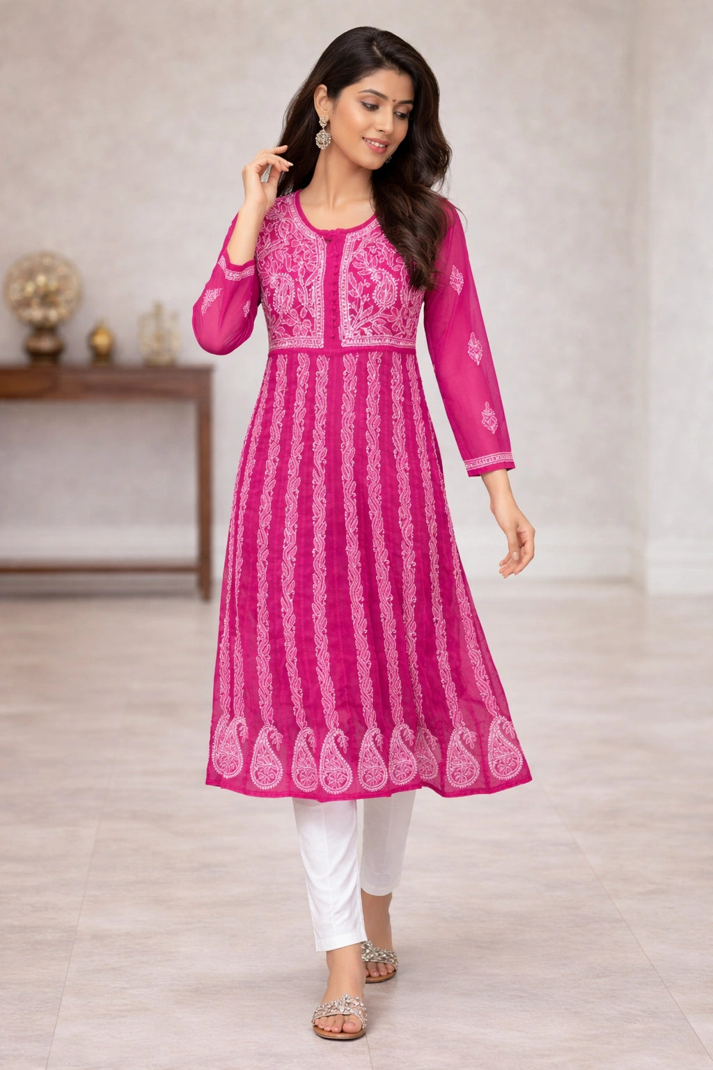 Woman wearing a pink embroidered kurta with white pants in an indoor setting