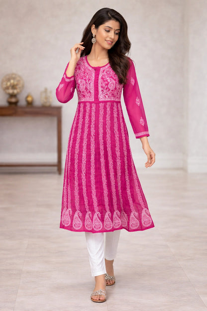 Woman wearing a pink embroidered kurta with white pants in an indoor setting
