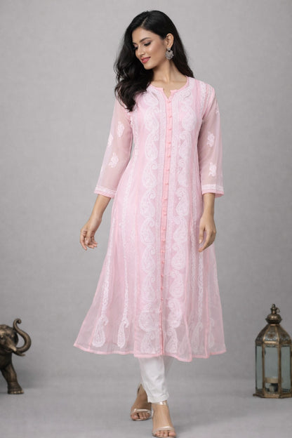 Woman wearing a light pink embroidered kurta with white pants on a gray background